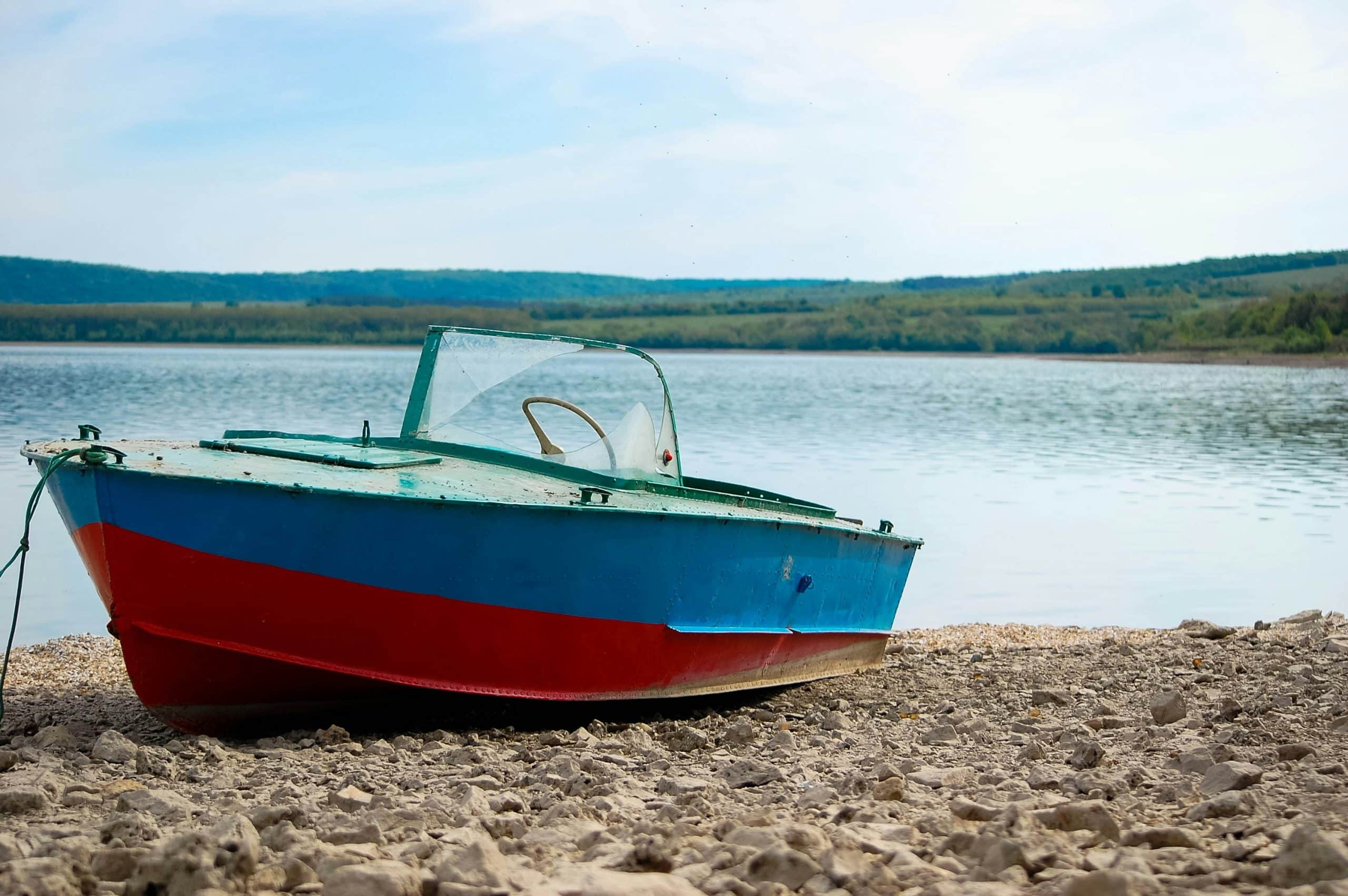 A modern aluminium fishing boat pulled up onto a quiet shore. Photo credit Oleksander Tomin